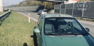 Na zdjęciu samochód na poboczu autostrady