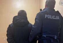 Policjant przetrzymuje w kajdankach sprawcę