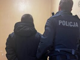 Policjant przetrzymuje w kajdankach sprawcę